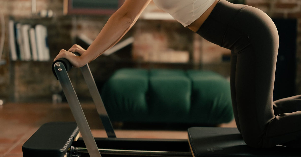 Elephant position over the footbar of a FitBoutique reformer